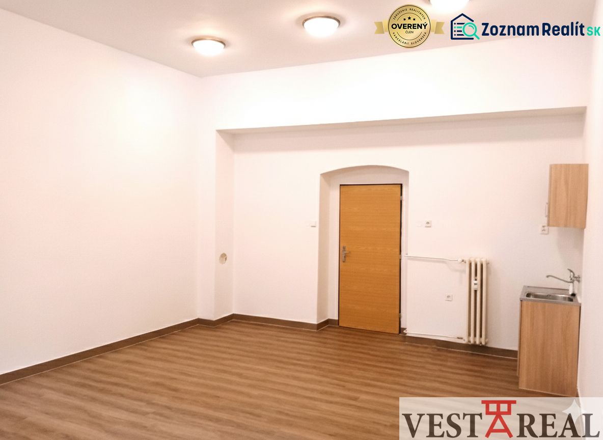 Kanceláře s podlahou s dřevěným dekorem, bílými stěnami a umyvadlem.