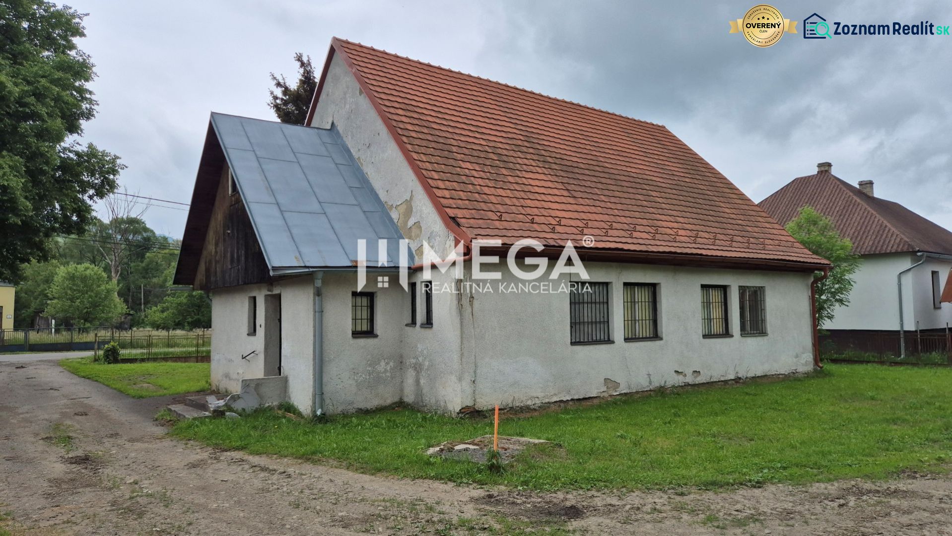 Budova s červenou střechou v Zboji obklopená zelení a sousedními domy, využitelná jako obchodní prostory.