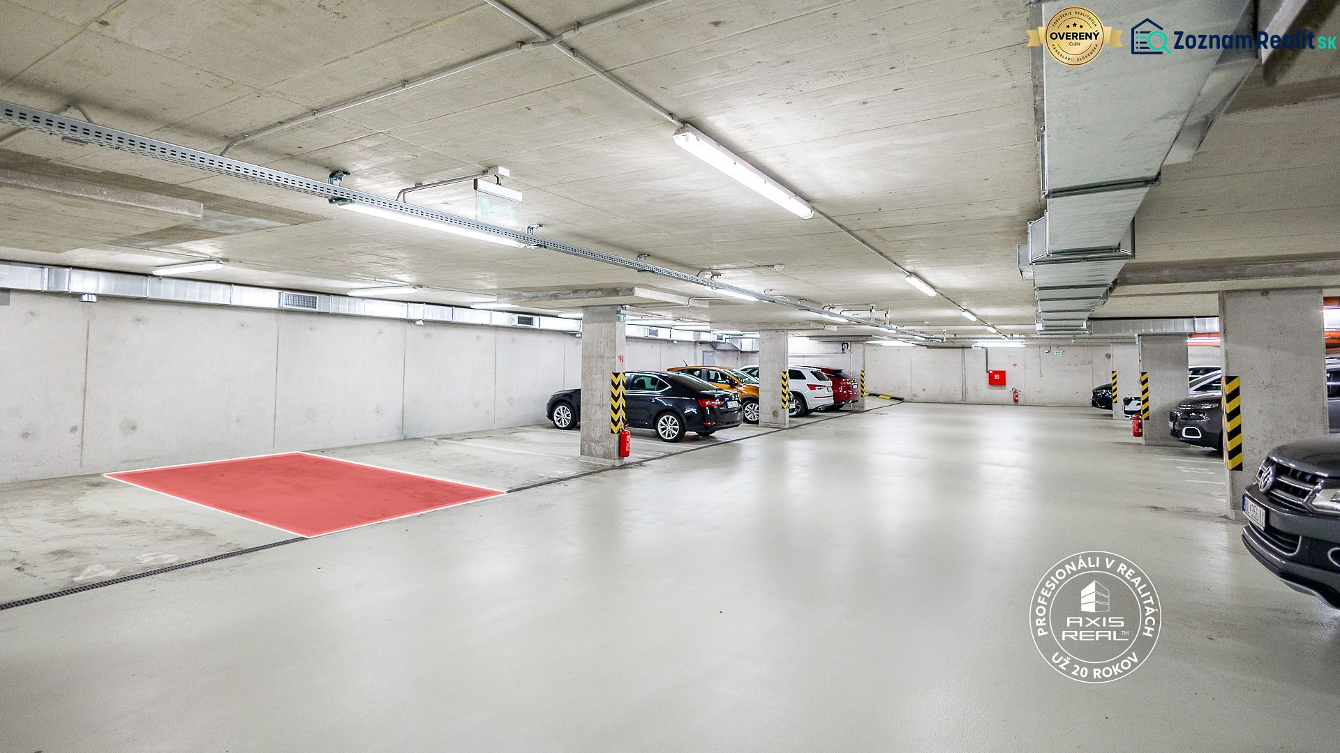 Podzemní garáže s parkovacími místy a betonovými sloupy.