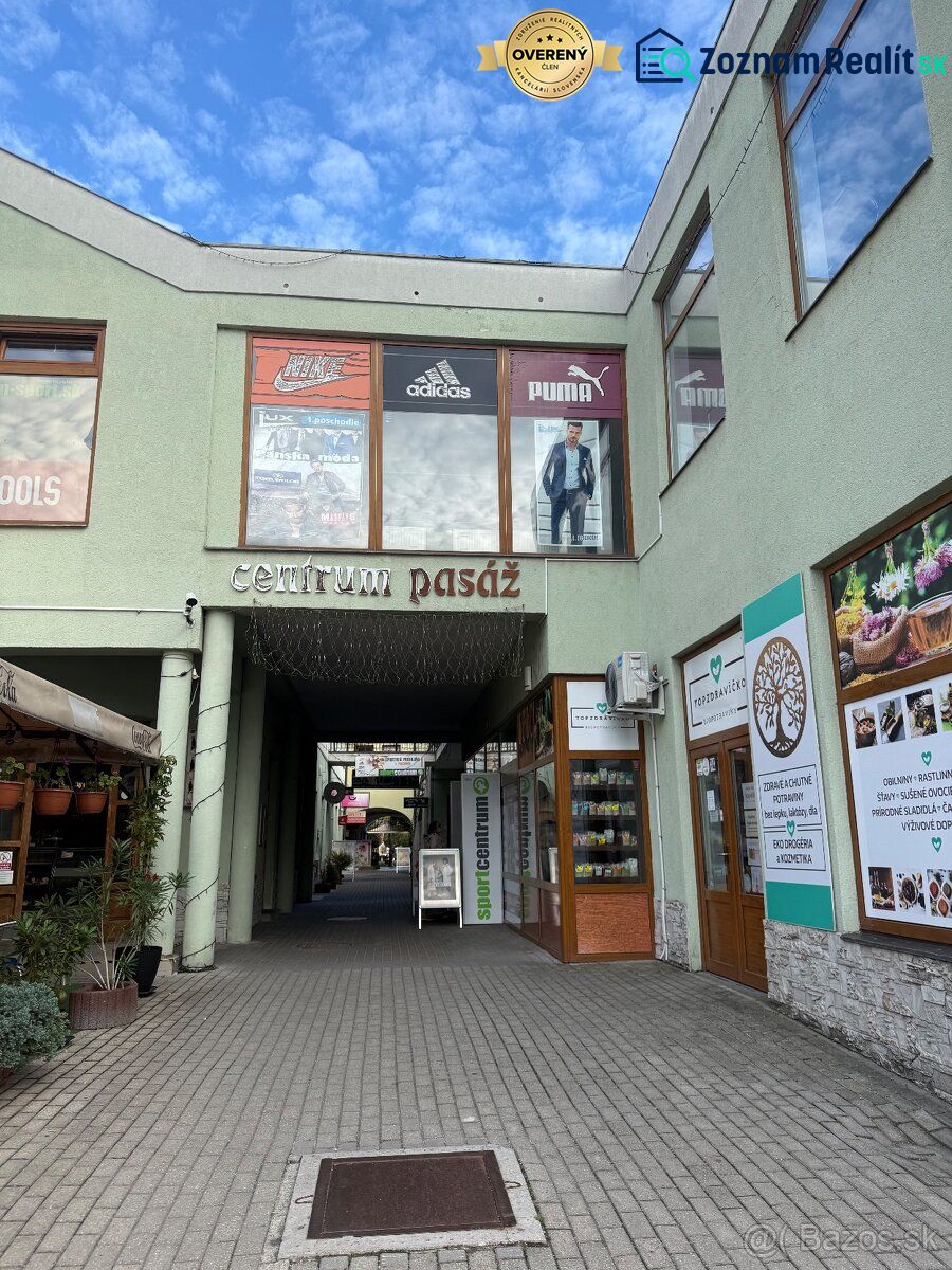 Obchodní prostory v Topoľčanech se vstupem do centra pasáže a pohledem na vitríny.