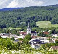 Malebná panoráma Lutile se zemědělskými a lesními pozemky a kostelem obklopeným zelenými lesy.