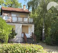 Chata v Radvaňi nad Dunajom, obklopená zelení s terasou a satelitem.