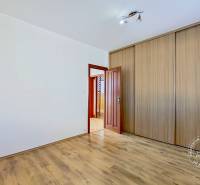 Pokoj s dřevěnou podlahou a vestavěnou skříní ve 4pokojovém bytě.