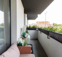 Balkon s posezením a květinami v 2-pokojovém bytě.