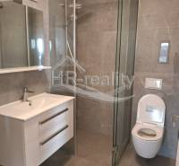 Koupelna v rekreačním apartmánu s moderní sprchou a zrcadlem.