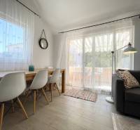 Rekreační apartmán nabízí světlý obývací prostor s jídelním stolem a pohodlnou pohovkou.