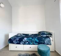Rekreační apartmán s postelí a modrým vzorovaným povlečením.