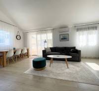 Prostorný obývací prostor rekreačního apartmánu s pohodlným posezením a jídelním stolem.