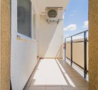 Balkon 2-pokojového bytu v Trenčíně s výhledem na slunečné modré nebe.