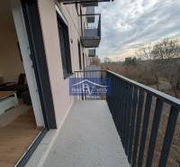 Balkon 2pokojového bytu na Hraniční ulici v Bratislavě - Ružinov, výhled na stromy.
