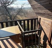 Balkon s dřevěným obkladem a výhledem do přírody, ideální pro rekreační pozemky.