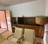Retro místnost: stará křesla, stolní lampa, knihovna; ideální pro rekreační pozemky.