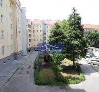 Dvůr bytového domu na Kalinčiakové v Bratislavě - Novém Městě s parkováním a hřištěm.