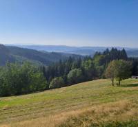 Panoramatický výhled na zalesněné kopce a louky v Olešné, vhodné na pozemky - bydlení.