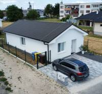 Rodinný dům v Nižné se zaparkovaným autem, nadčasová architektura a okolní krajina.