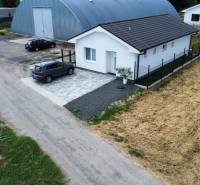 Rodinný dům v Nižné s asfaltovou cestou a zaparkovaným autem.