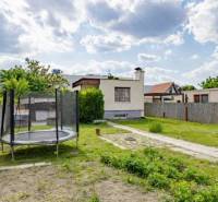 Zahrada rodinného domu na Mokráň záhon v Bratislavě-Ružinově s trampolínou a plotem.