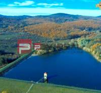Jezero obklopené podzimní krajinou v oblasti Pezinku, vhodné pro Pozemky - bydlení.