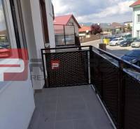 Balkon 2-pokojového bytu na ulici Slavomírova, výhled na okolní zástavbu a auta.