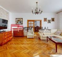Stylový obývací pokoj s elegantní sedačkou a nábytkem ze dřeva v rodinném domě.