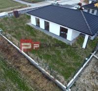 Rodinný dům v Časté se šikmou střechou, obehnaný plotem, travnatý pozemek.