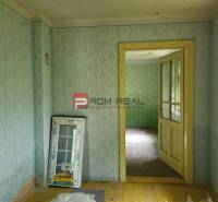Interiér s tapetami a starou podlahou, Pozemky - bydlení. Dodává venkovskou atmosféru.