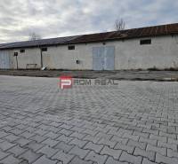 Exteriér průmyslové budovy na ulici Partizánská, sklady a haly na dlažbě.
