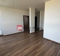 Interiér 2-pokojového bytu s dřevěnou podlahou a prostorným balkonem.