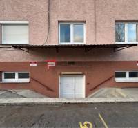 Vstup do skladů a hal na Púchovské ulici v Bratislavě III s parkovacími místy.