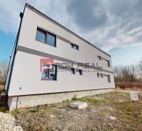Exteriér rodinného domu v Dunajské Stredě s minimalistickým fasádním designem.