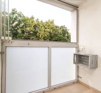 Balkon v 3-pokojovém bytě s výhledem na stromy, který je součástí nemovitosti.