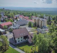 Letecký pohled na rekreační apartmány ve Vysokých Tatrách obklopené přírodou a zelení.