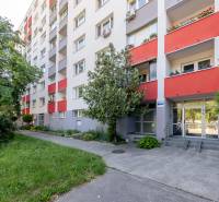 Bytový dům s červenými balkóny a zelení na Wolkrově ulici v Bratislavě - Petržalce.