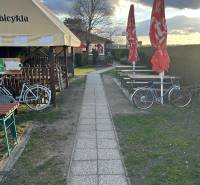 Chodník vedle gastro prostor s koly a slunečníky, Devínska Nová Ves, Devínské jezero.