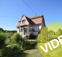 Rodinný dům v Topoľčiankách s tradiční architekturou, obklopený zelení a trávníkem.