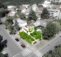 Rodinný dům v lokalitě Bratislava - Staré Město, obklopený zelení a cestou s auty.