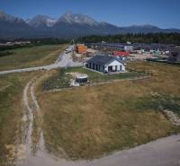 Pozemky na bydlení v Mlynici s výhledem na Tatry, venkovský dům a stavby v pozadí.