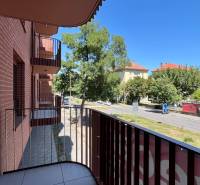 Balkon bytu na ulici Cvernovka v Bratislavě - Ružinově se zelení a silnicí.