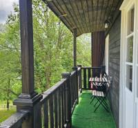Balkon rodinného domu s dřevěným zábradlím a výhledem na přírodu v Donovalech.