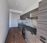 Kuchyně v 2-pokojovém bytě se světlým podlahovým designem a moderním vybavením.