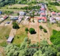 Pozemky - bydlení na ulici Mlýnská v Bělu, s travnatými a zalesněnými plochami.