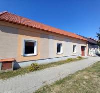 Rodinný dům v Trakovicích s oranžovou fasádou a červenou střechou.