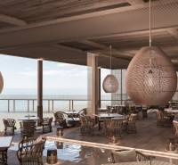 Luxusní restaurace s výhledem na oceán, stylová závěsná svítidla, komfortní sezení.