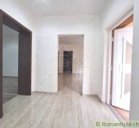 Chodba rodinného domu s laminátovou podlahou a bílými stěnami.