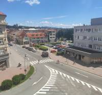 Ulice J. Kotáčka ve Zvolenu s kancelářemi, obchody a auty na parkovišti.