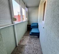 Balkon 4pokojového bytu s dlažbou a posuvnými okny na sídlišti.