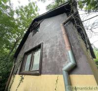 Rodinný dům v Branči s omítkou, popínavými rostlinami a dřevěnými okny.