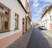 Ulice Vrátna v Košicích, Staré Město, s historickými fasádami a zaparkovanými auty.