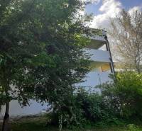 Vila v Hainburgu an der Donau obklopená zelení s částečně odkrytými poschodími.