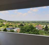 Pohled z vily v Hainburg an der Donau, obklopený přírodou a střechami domů.